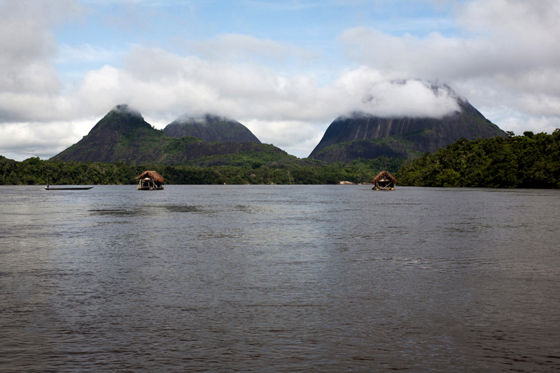 Gold dredgers seen in the Inirida river with the Mavicure range on the background, Guanía, Colombia.