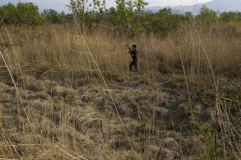 A policeman patrolls train tracks surroundings in search for robbers who usually hide in the fields in hopes to steal from illegal immigrants. Arriaga, Mexico
